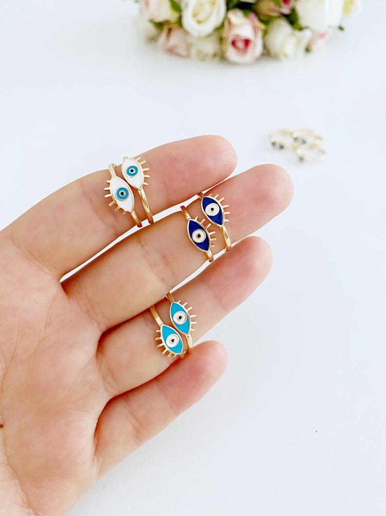 Gold Dainty Evil Eye Ring featuring a thin band and an oval evil eye charm in blue, turquoise, and white colors.