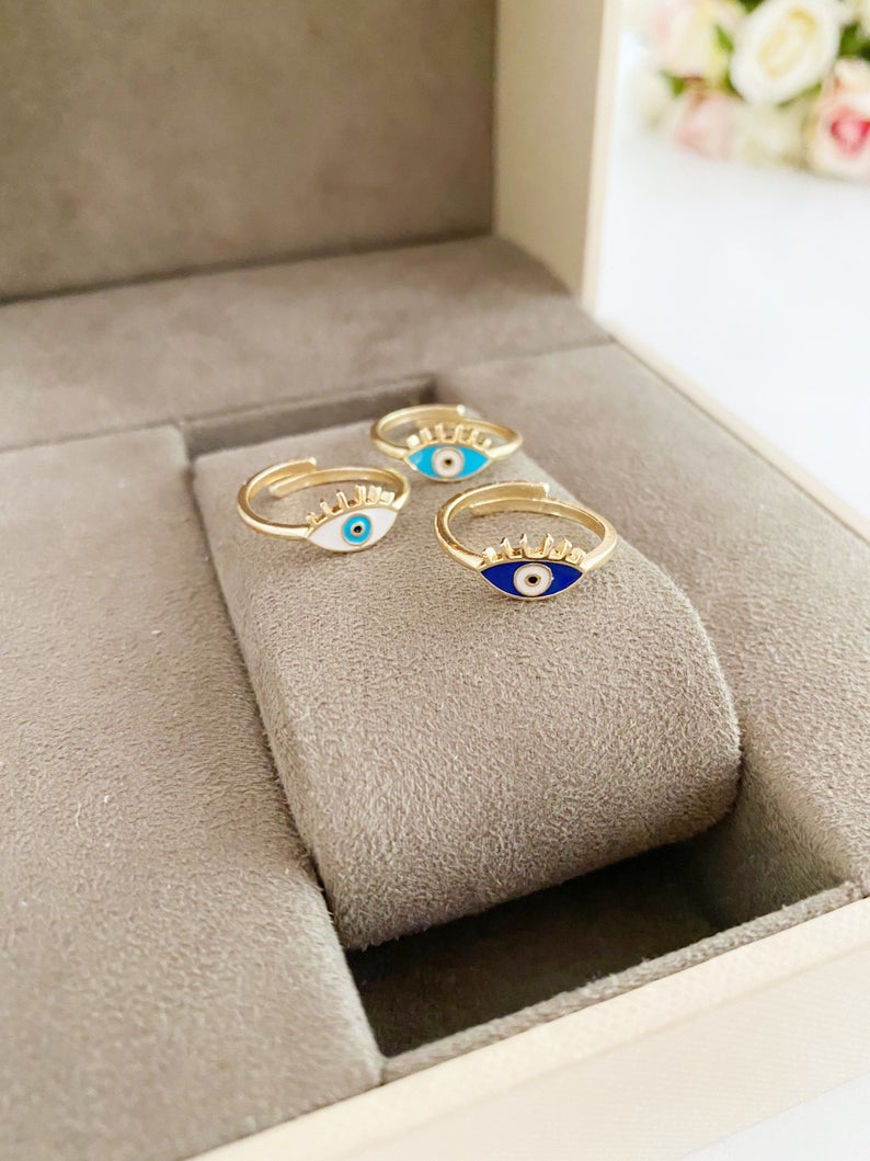 Gold Dainty Evil Eye Ring featuring a thin band and an oval evil eye charm in blue, turquoise, and white colors.