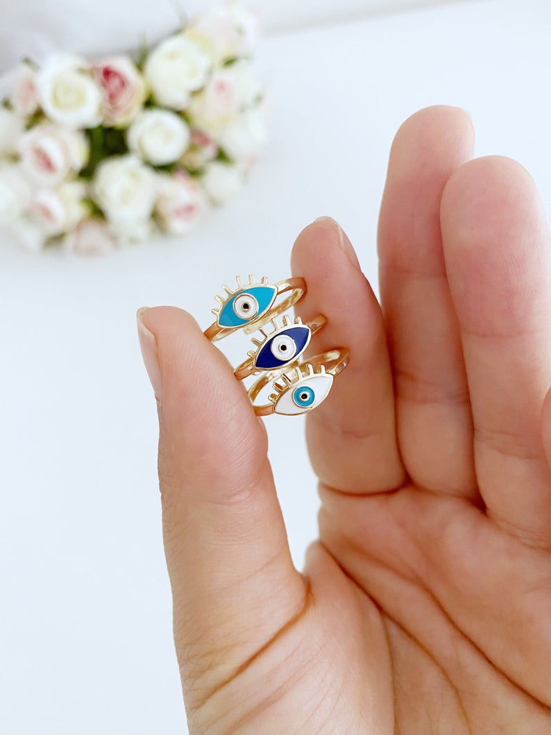 Gold Dainty Evil Eye Ring featuring a thin band and an oval evil eye charm in blue, turquoise, and white colors.