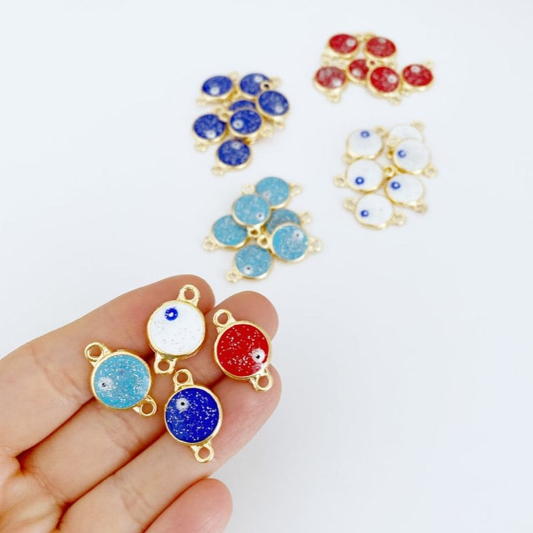 A collection of five gold evil eye beads with a glittering finish, showcasing their intricate design and vibrant colors, perfect for DIY jewelry projects.