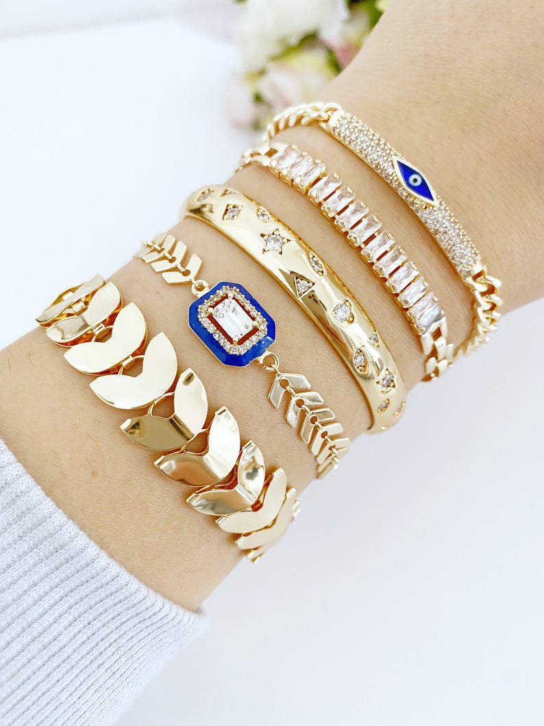 Gold Evil Eye Bracelet featuring a blue evil eye charm, crafted from durable stainless steel with a gold finish, adjustable design for all wrist sizes.