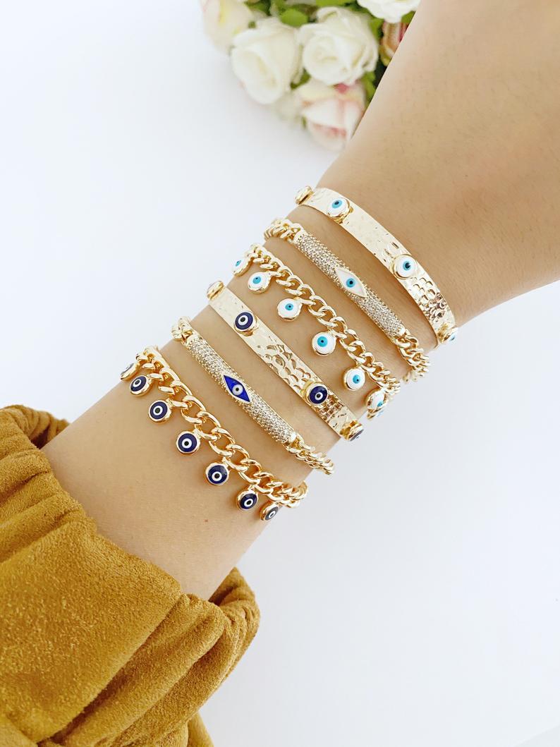 Gold Evil Eye Bracelet featuring blue and white evil eye bead, adjustable cuff design, handmade from tarnish-resistant stainless steel.