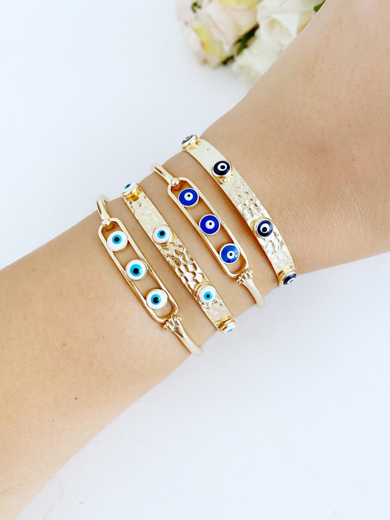 Gold Evil Eye Bracelet featuring a movable blue and white charm on a stainless steel cuff, elegantly designed for protection and style.