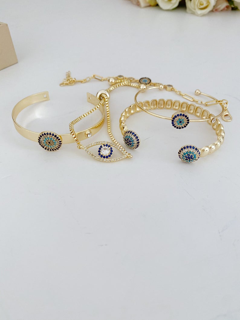 Gold Evil Eye Bracelet featuring a zircon evil eye bead, handmade with tarnish-resistant stainless steel, adjustable cuff design.