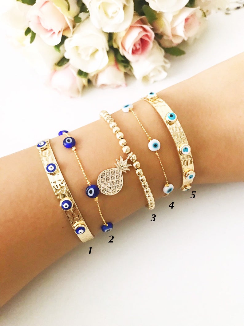 Gold Evil Eye Bracelet Set featuring adjustable bangles and tiny evil eye beads, showcasing handmade craftsmanship and durable stainless steel.