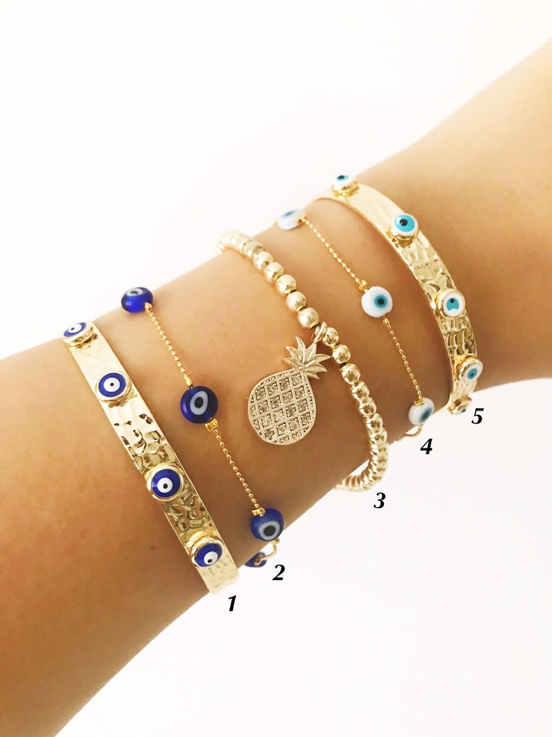 Gold Evil Eye Bracelet Set featuring adjustable bangles and tiny evil eye beads, showcasing handmade craftsmanship and durable stainless steel.