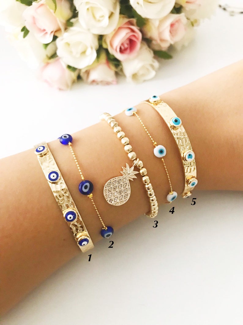 Gold Evil Eye Bracelet Set featuring adjustable bangles and tiny evil eye beads, showcasing handmade craftsmanship and durable stainless steel.