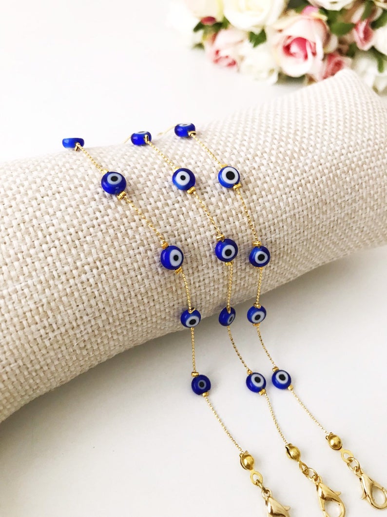 Gold Evil Eye Bracelet Set featuring adjustable bangles and tiny evil eye beads, showcasing handmade craftsmanship and durable stainless steel.