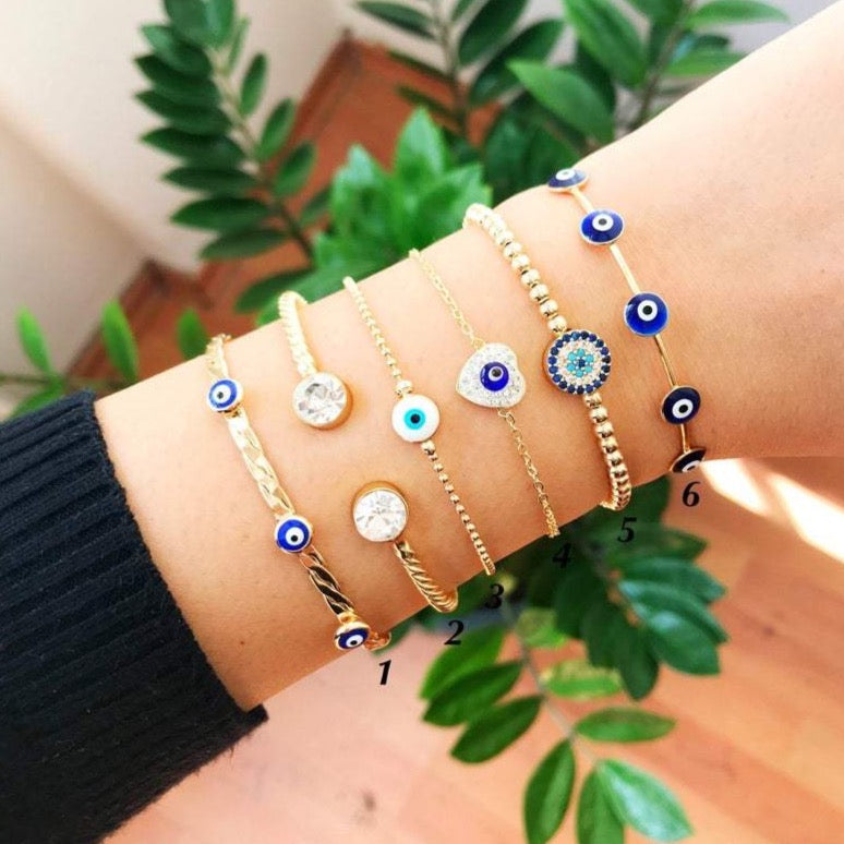 Gold Evil Eye Bracelet Set featuring adjustable bangles and cuffs with intricate designs, showcasing the protective evil eye symbol.