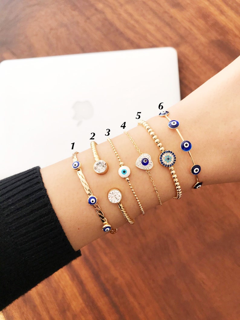 Gold Evil Eye Bracelet Set featuring adjustable bangles and cuffs with intricate designs, showcasing the protective evil eye symbol.