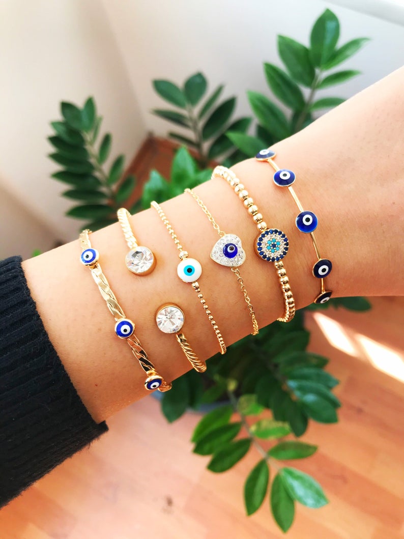 Gold Evil Eye Bracelet Set featuring adjustable bangles and cuffs with intricate designs, showcasing the protective evil eye symbol.