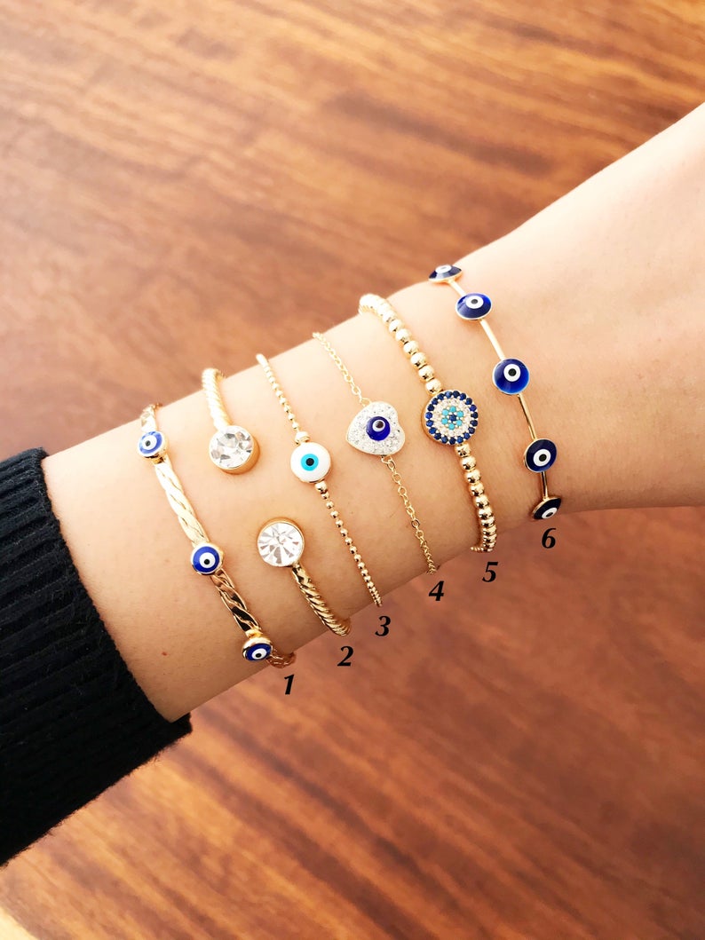 Gold Evil Eye Bracelet Set featuring adjustable bangles and cuffs with intricate designs, showcasing the protective evil eye symbol.