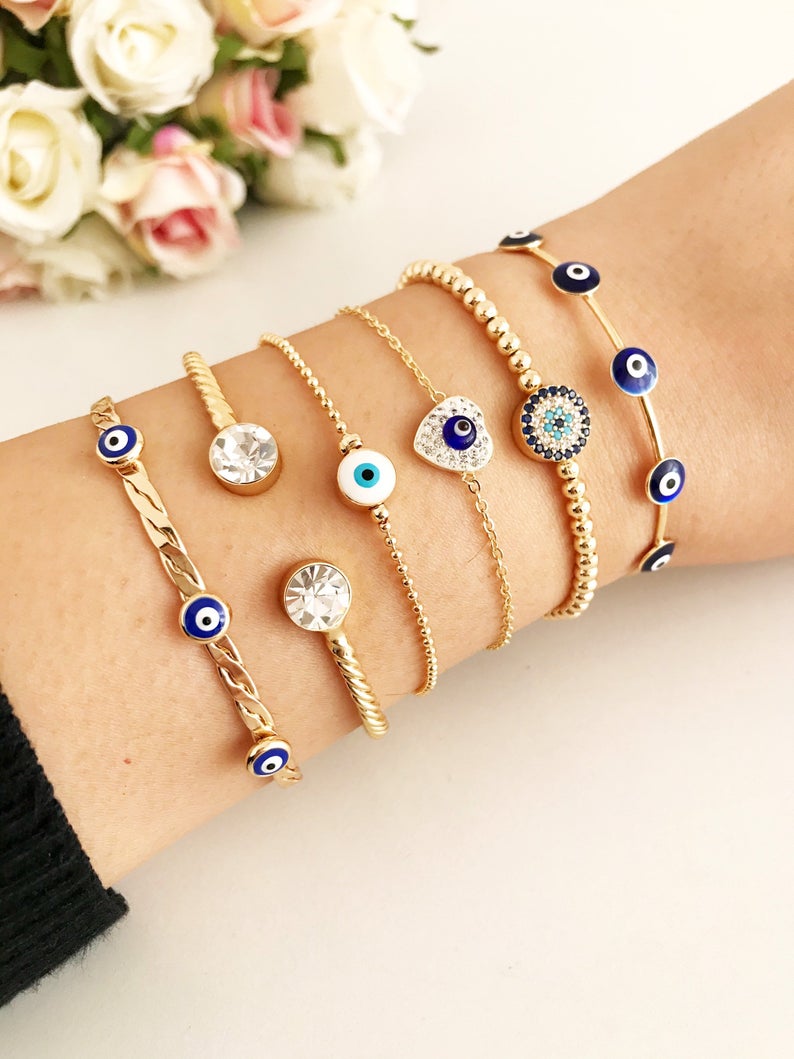 Gold Evil Eye Bracelet Set featuring adjustable bangles and cuffs with intricate designs, showcasing the protective evil eye symbol.