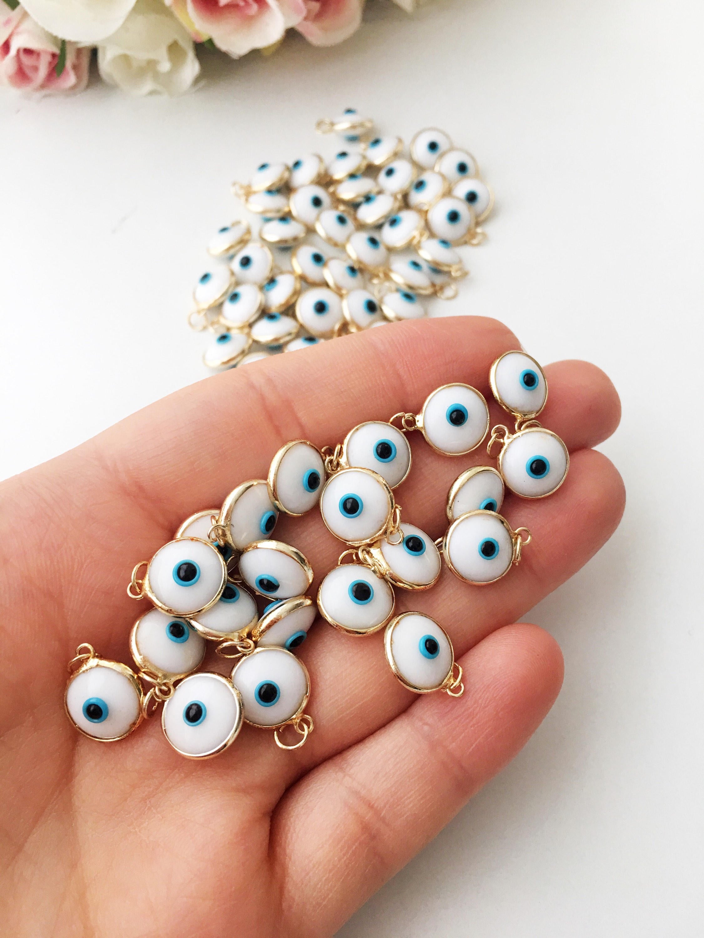 Gold evil eye charm featuring blue evil eye beads, perfect for DIY jewelry making, showcasing a delicate design and vibrant colors.