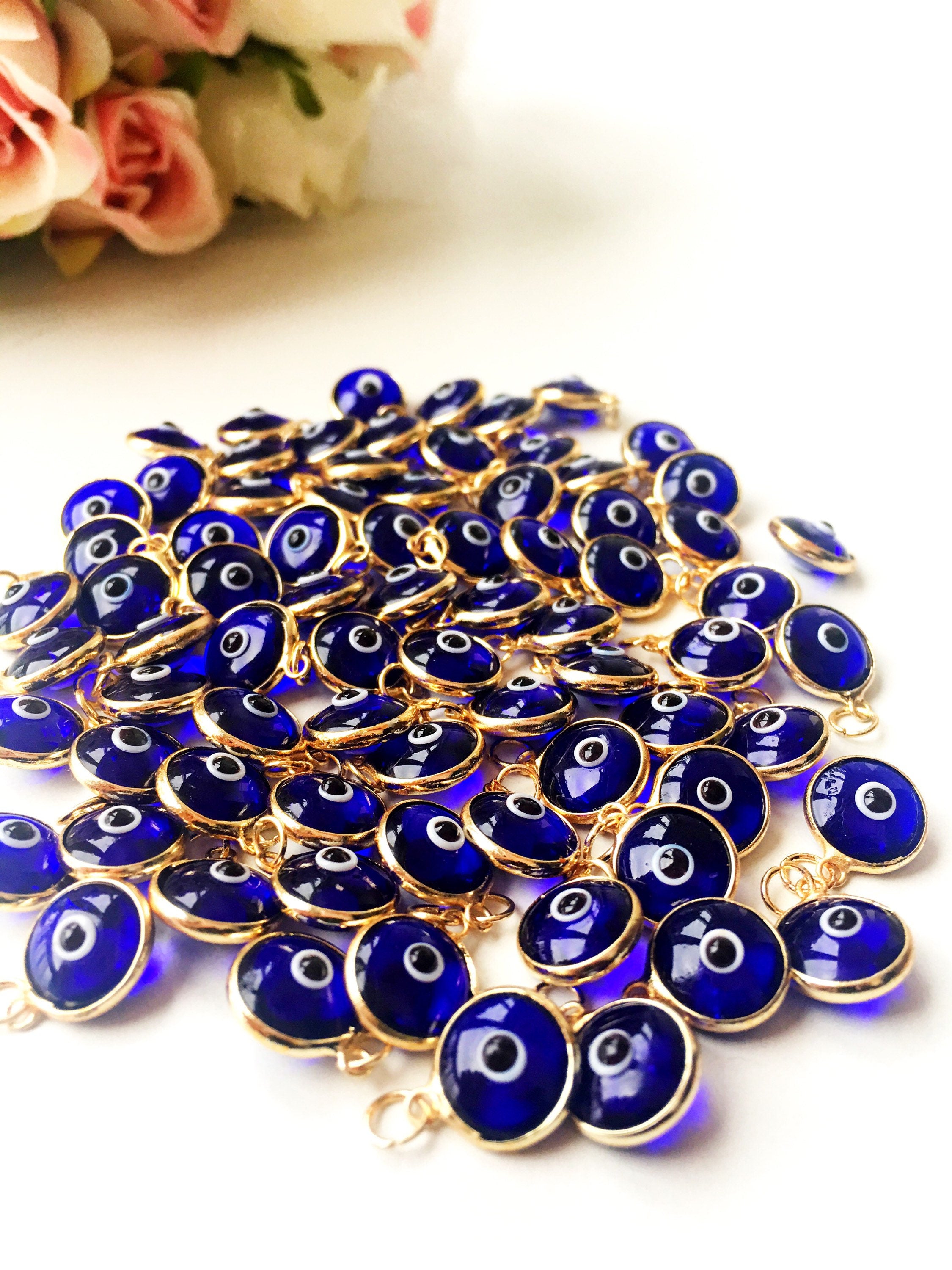 Gold evil eye charm featuring blue evil eye beads, perfect for DIY jewelry making, showcasing a delicate design and vibrant colors.