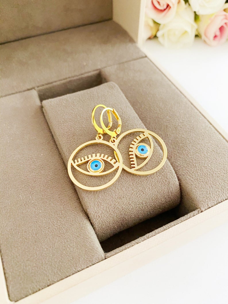 A pair of handmade gold hoop earrings featuring a Greek evil eye bead, symbolizing protection and good luck, measuring 25mm in diameter.