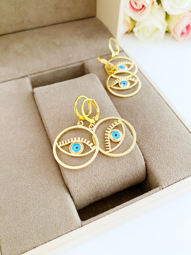 A pair of handmade gold hoop earrings featuring a Greek evil eye bead, symbolizing protection and good luck, measuring 25mm in diameter.