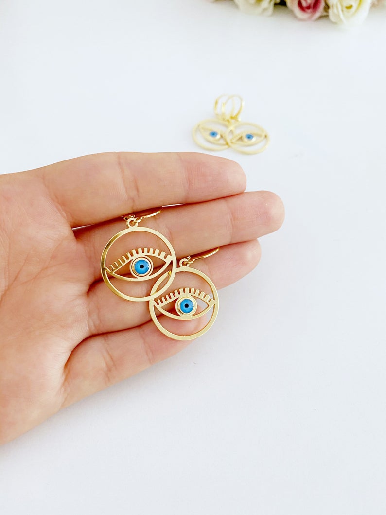 A pair of handmade gold hoop earrings featuring a Greek evil eye bead, symbolizing protection and good luck, measuring 25mm in diameter.