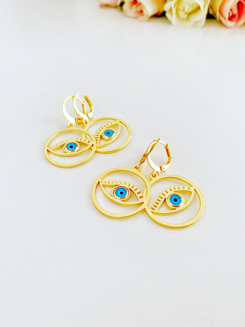 A pair of handmade gold hoop earrings featuring a Greek evil eye bead, symbolizing protection and good luck, measuring 25mm in diameter.