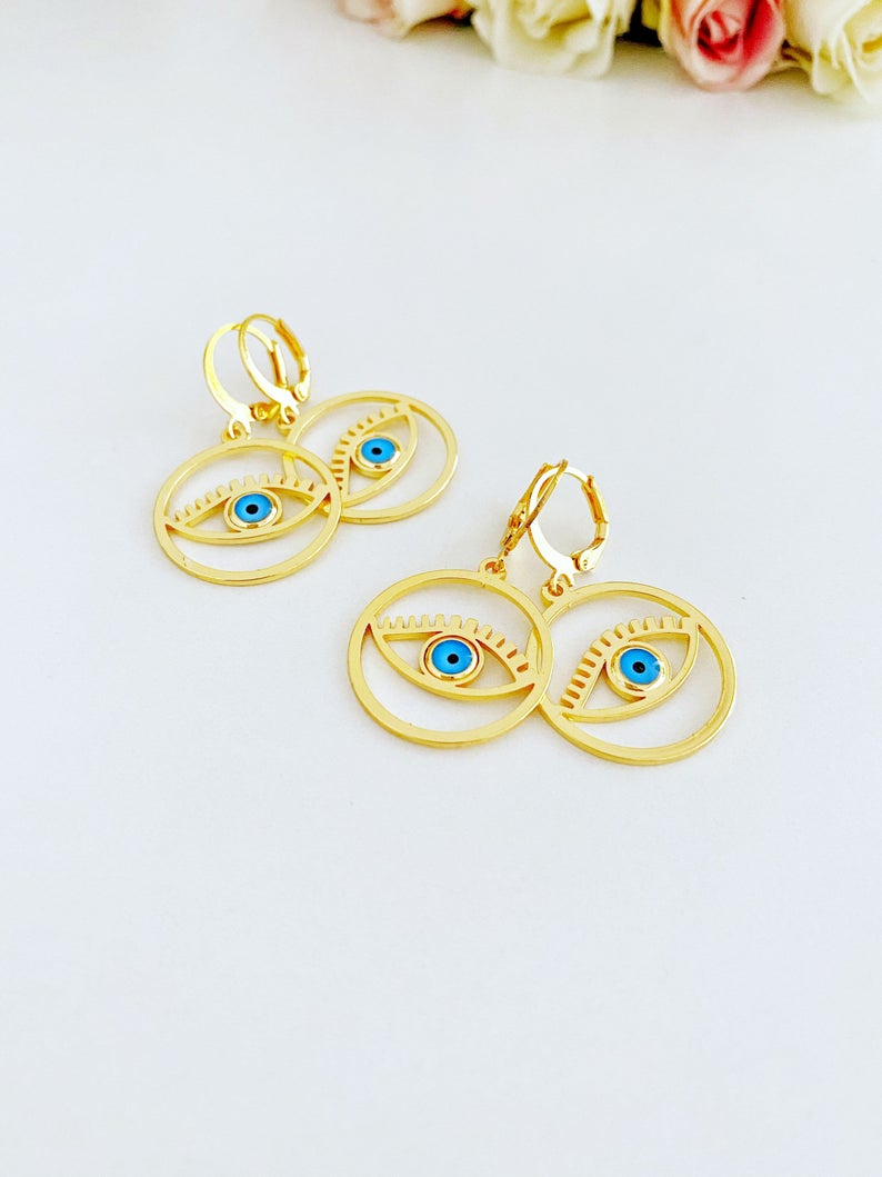 A pair of handmade gold hoop earrings featuring a Greek evil eye bead, symbolizing protection and good luck, measuring 25mm in diameter.