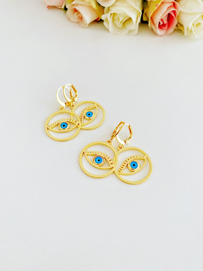 A pair of handmade gold hoop earrings featuring a Greek evil eye bead, symbolizing protection and good luck, measuring 25mm in diameter.