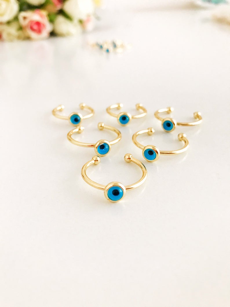 A delicate gold evil eye ring featuring a round blue evil eye bead on a thin adjustable band, perfect for everyday wear.