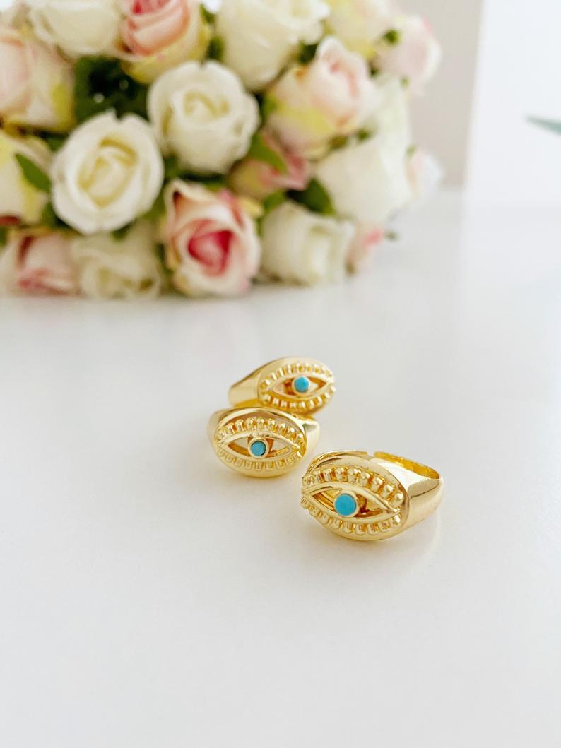 Gold Evil Eye Ring featuring a turquoise bead and adjustable band, symbolizing protection and style.