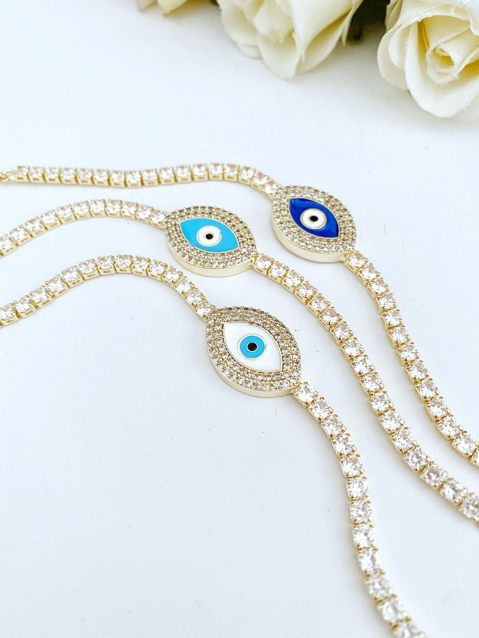 Gold Evil Eye Tennis Bracelet featuring a blue evil eye design, adjustable stainless steel material, and elegant gold finish.