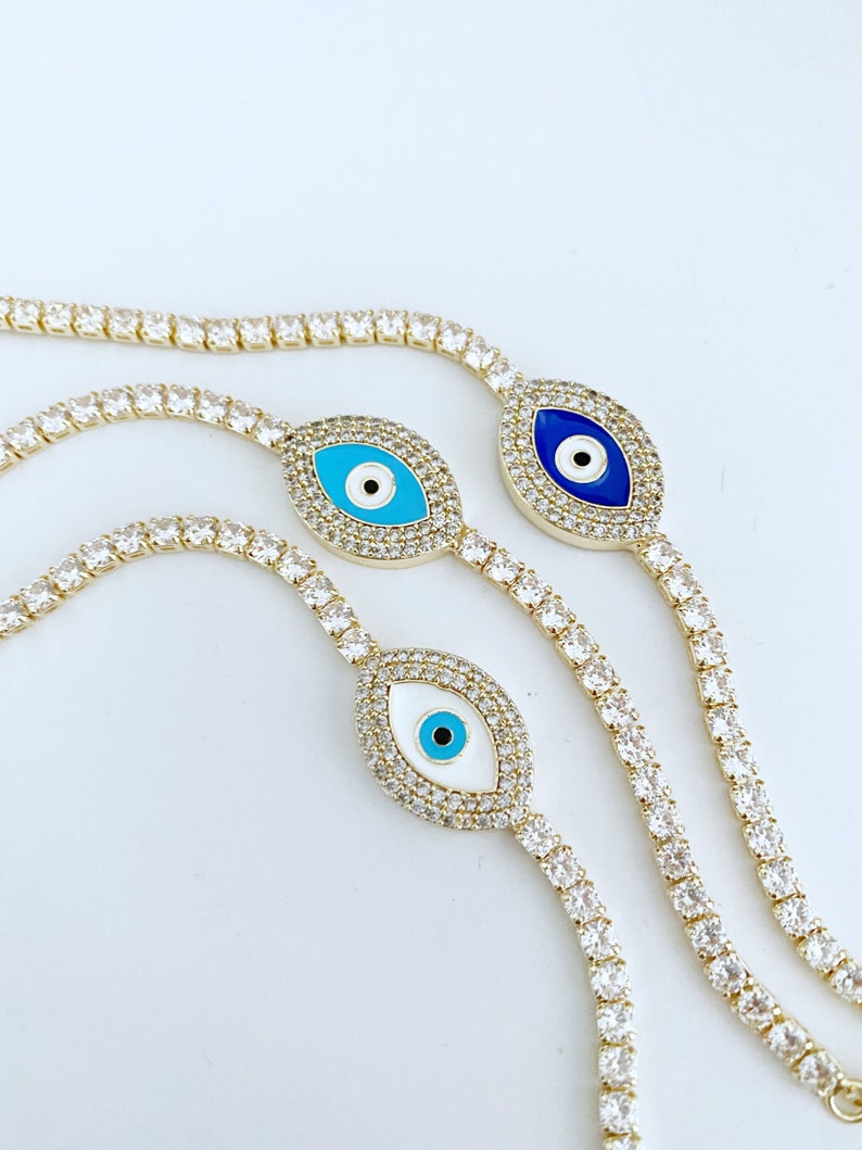 Gold Evil Eye Tennis Bracelet featuring a blue evil eye design, adjustable stainless steel material, and elegant gold finish.