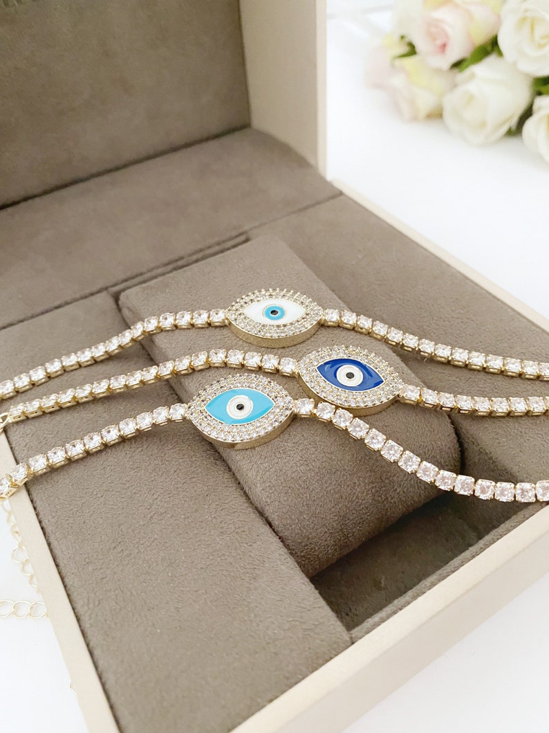 Gold Evil Eye Tennis Bracelet featuring a blue evil eye design, adjustable stainless steel material, and elegant gold finish.