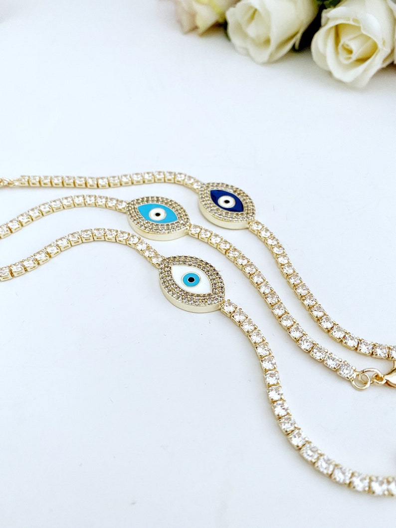 Gold Evil Eye Tennis Bracelet featuring a blue evil eye design, adjustable stainless steel material, and elegant gold finish.