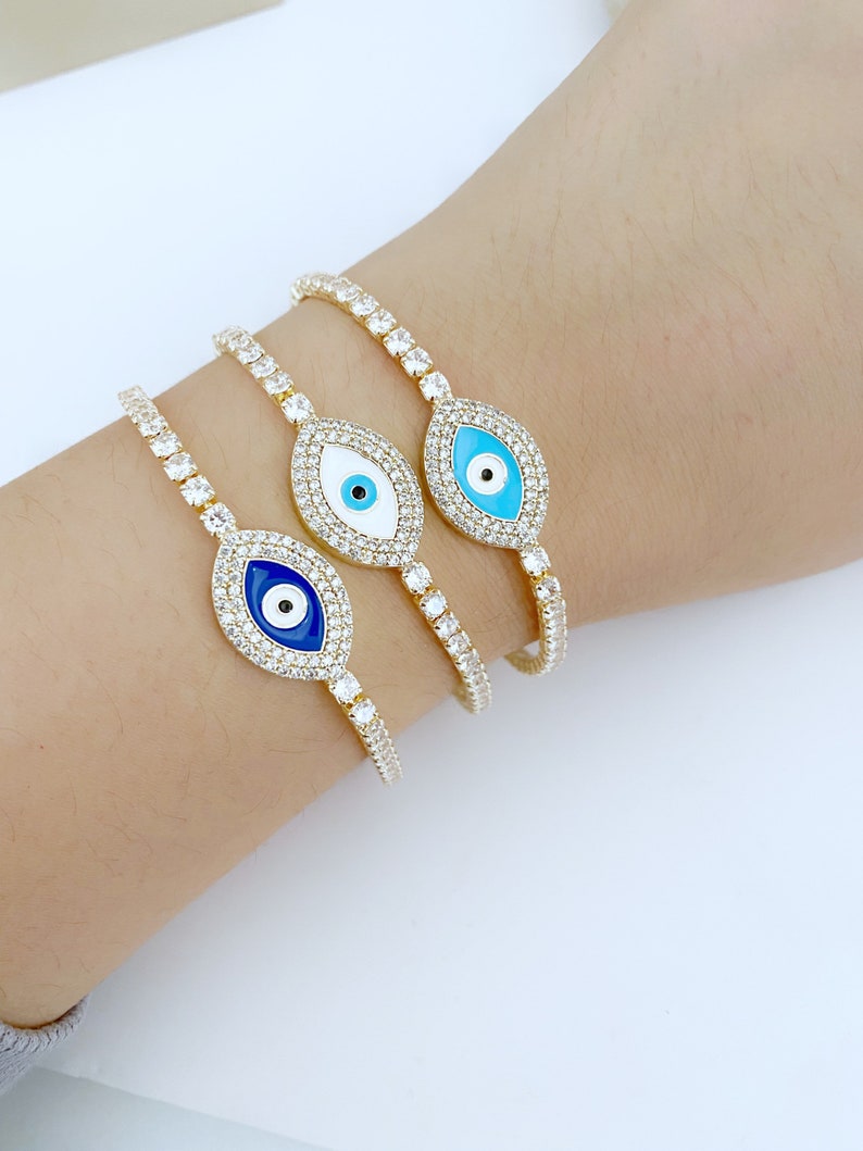 Gold Evil Eye Tennis Bracelet featuring a blue evil eye design, adjustable stainless steel material, and elegant gold finish.