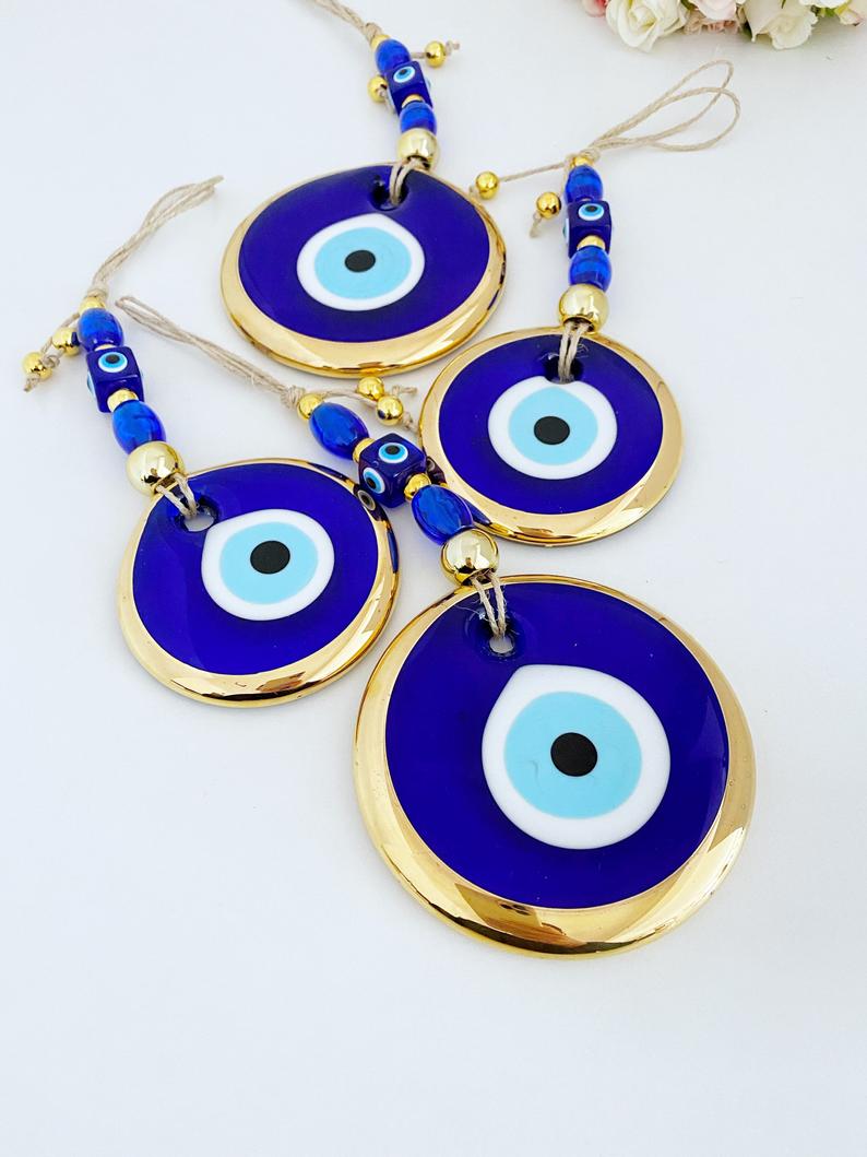 Gold Evil Eye Wall Hanging featuring a large evil eye bead, handmade with intricate details, perfect for home decor and Christmas tree decoration.