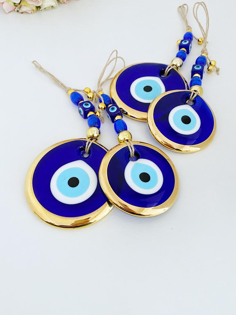 Gold Evil Eye Wall Hanging featuring a large evil eye bead, handmade with intricate details, perfect for home decor and Christmas tree decoration.