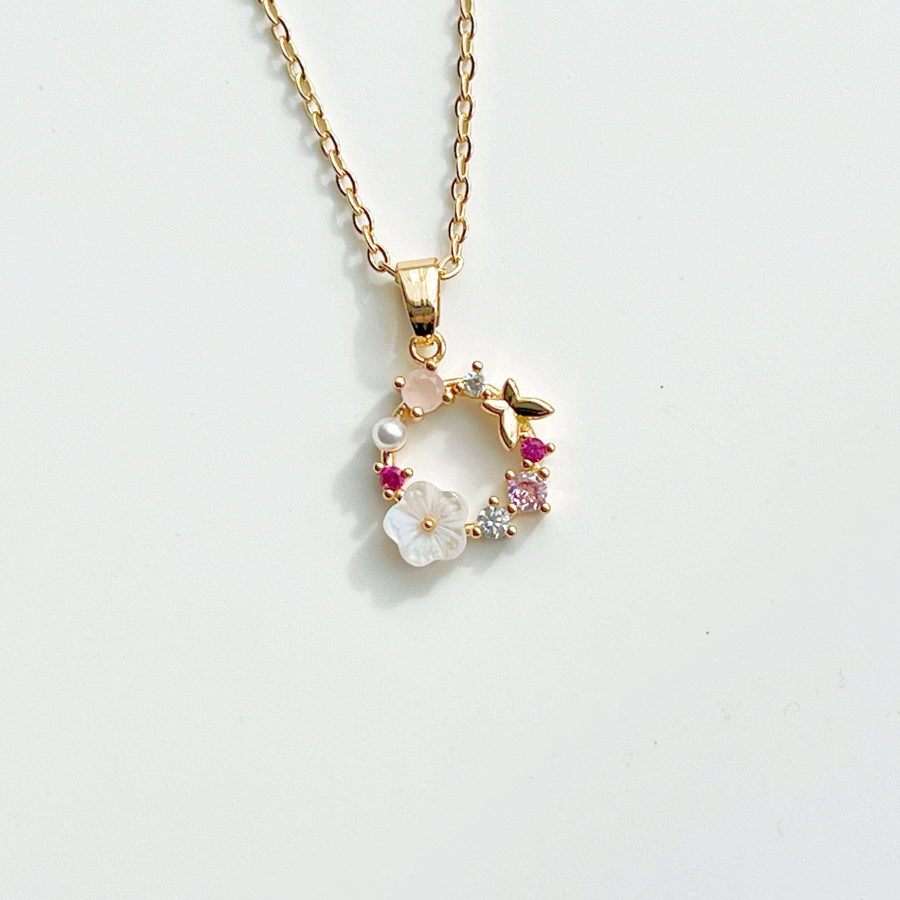 Gold Flower Wreath Charm Necklace featuring pink crystals and pearls, elegantly designed for meaningful gifting.