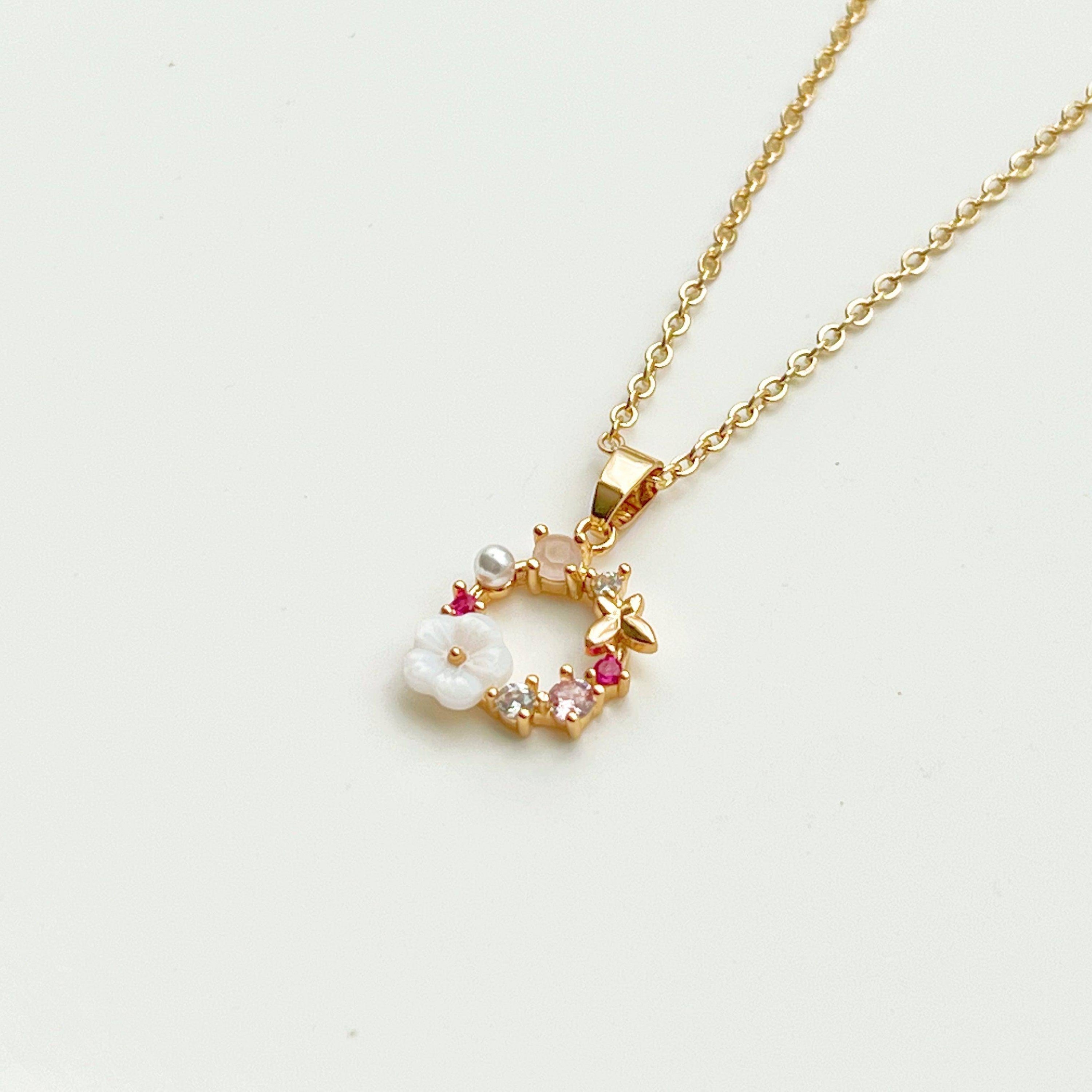 Gold Flower Wreath Charm Necklace featuring pink crystals and pearls, elegantly designed for meaningful gifting.