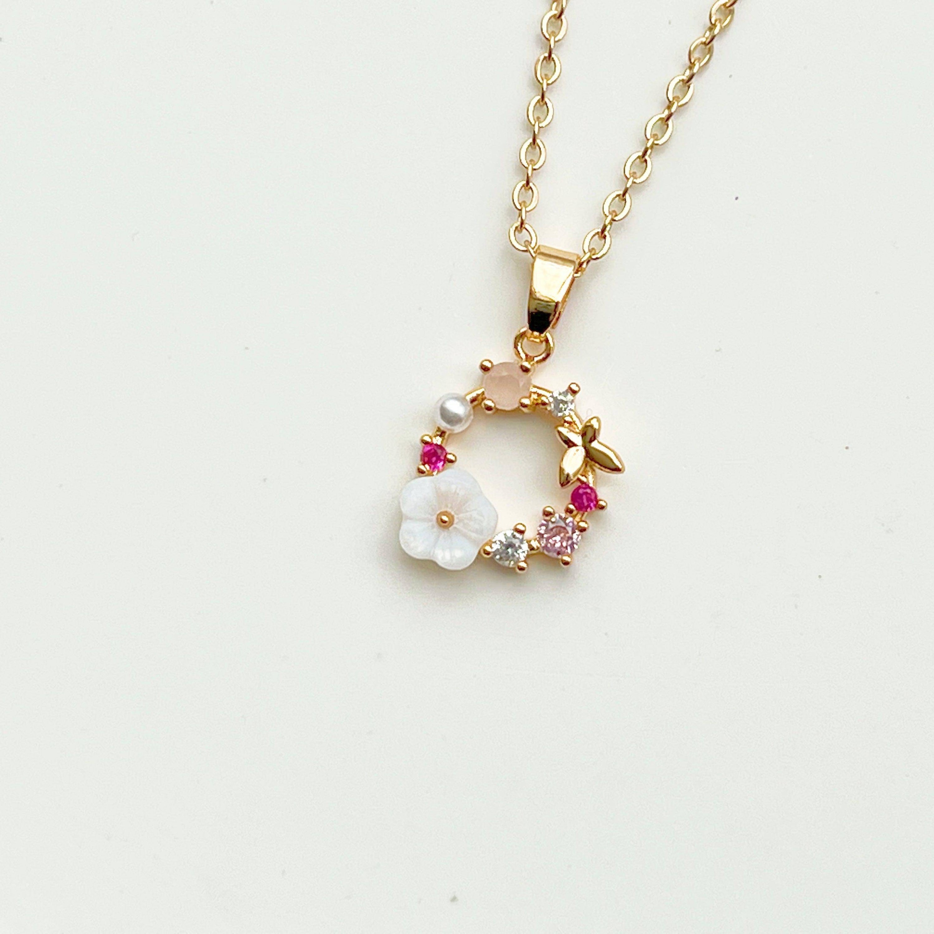 Gold Flower Wreath Charm Necklace featuring pink crystals and pearls, elegantly designed for meaningful gifting.