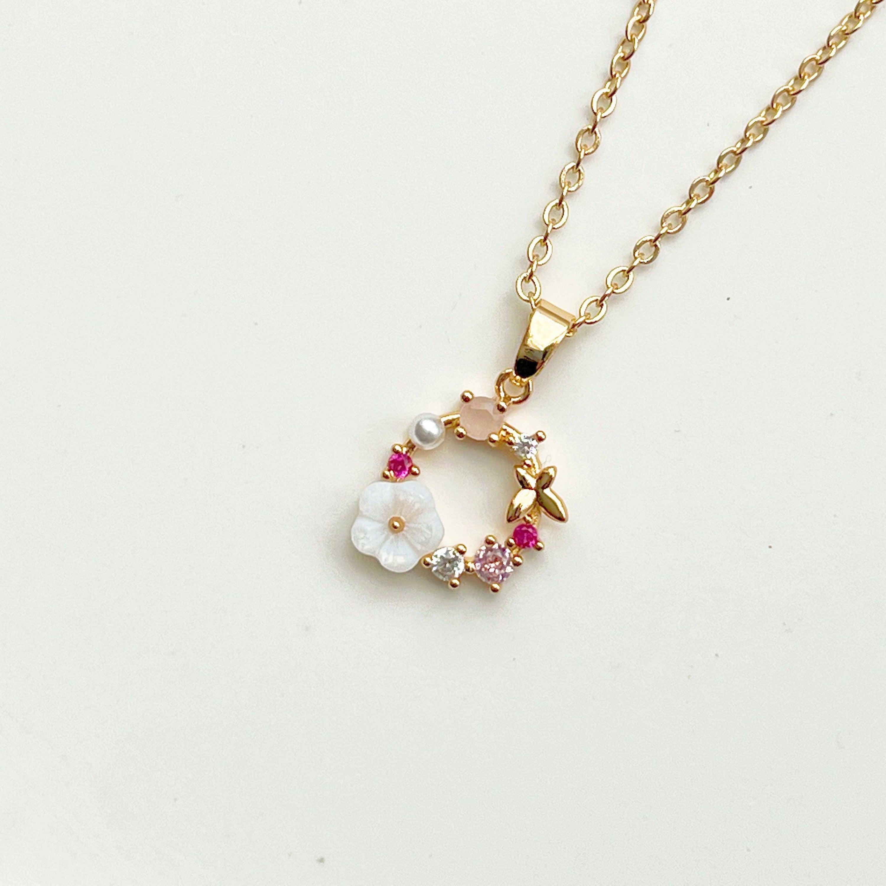 Gold Flower Wreath Charm Necklace featuring pink crystals and pearls, elegantly designed for meaningful gifting.