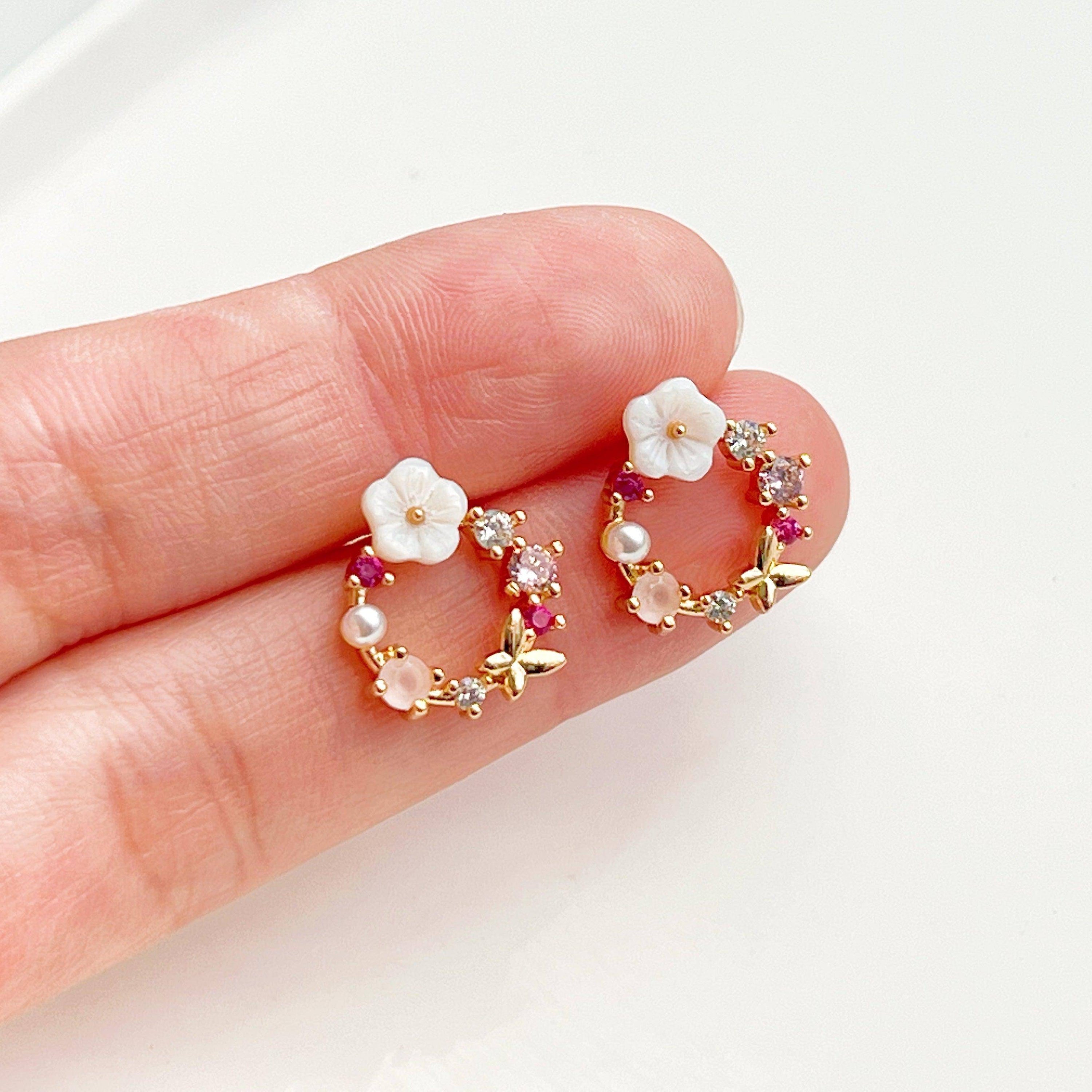 Elegant gold flower wreath earrings with pink crystals and pearls, showcasing a delicate floral design.