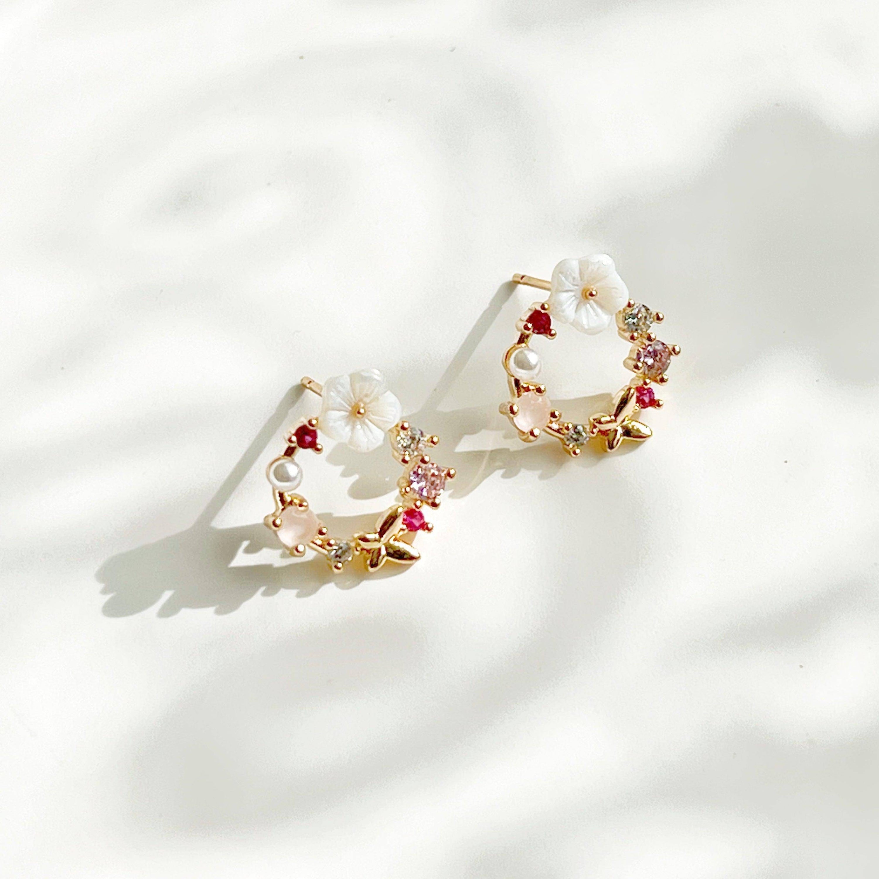 Elegant gold flower wreath earrings with pink crystals and pearls, showcasing a delicate floral design.