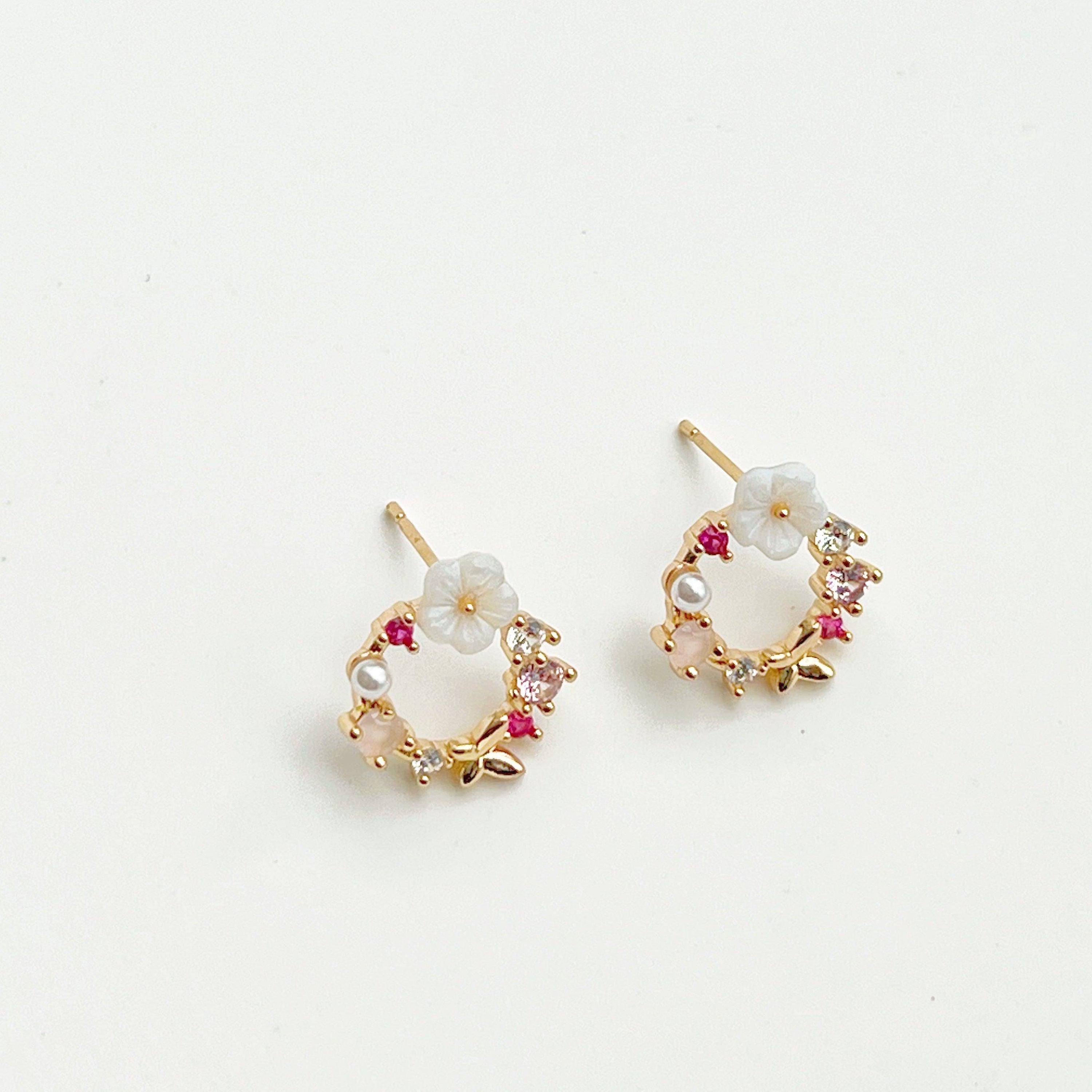 Elegant gold flower wreath earrings with pink crystals and pearls, showcasing a delicate floral design.