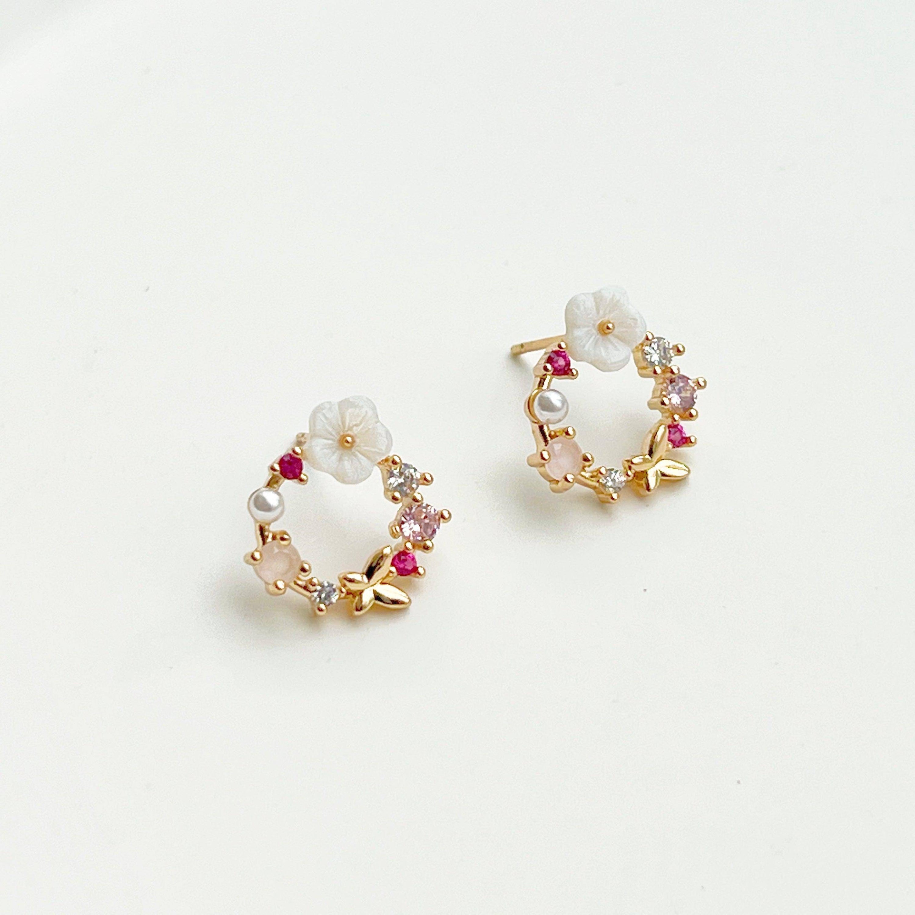 Elegant gold flower wreath earrings with pink crystals and pearls, showcasing a delicate floral design.