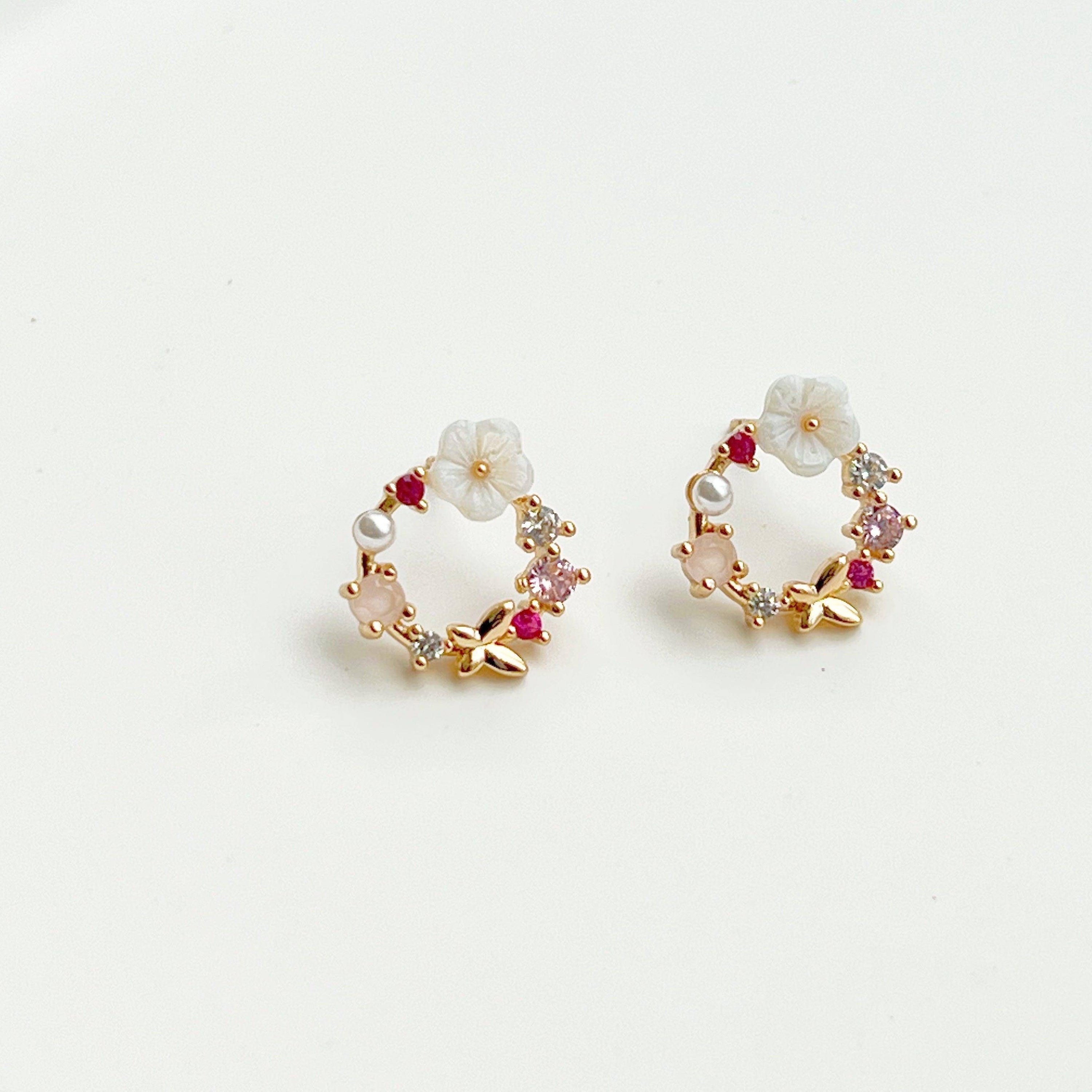 Elegant gold flower wreath earrings with pink crystals and pearls, showcasing a delicate floral design.