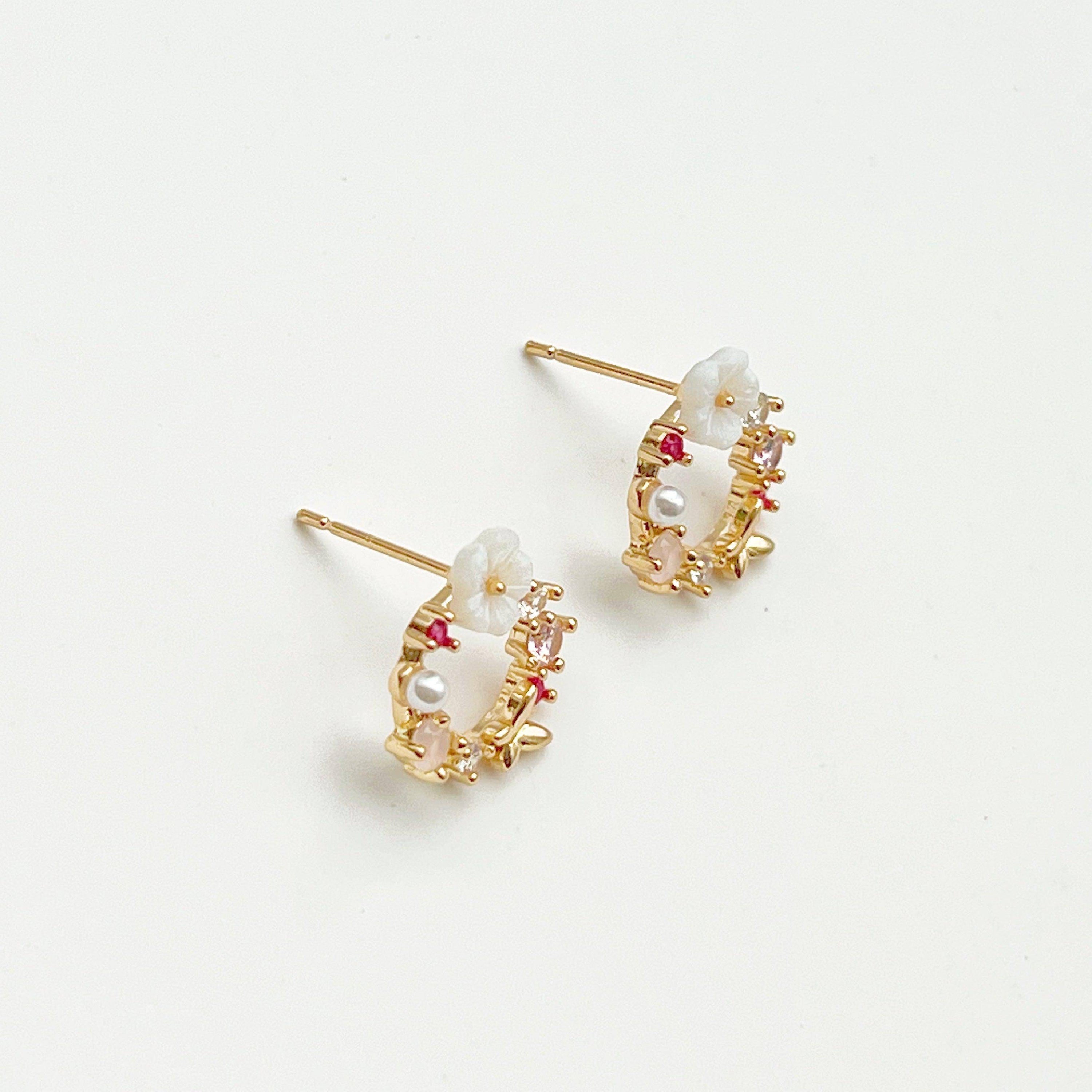 Elegant gold flower wreath earrings with pink crystals and pearls, showcasing a delicate floral design.