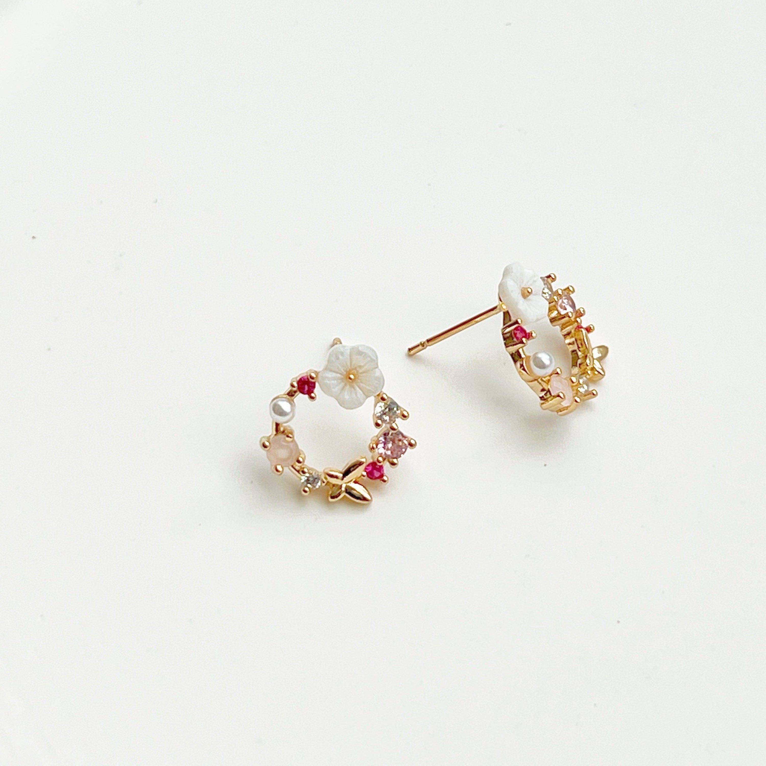 Elegant gold flower wreath earrings with pink crystals and pearls, showcasing a delicate floral design.