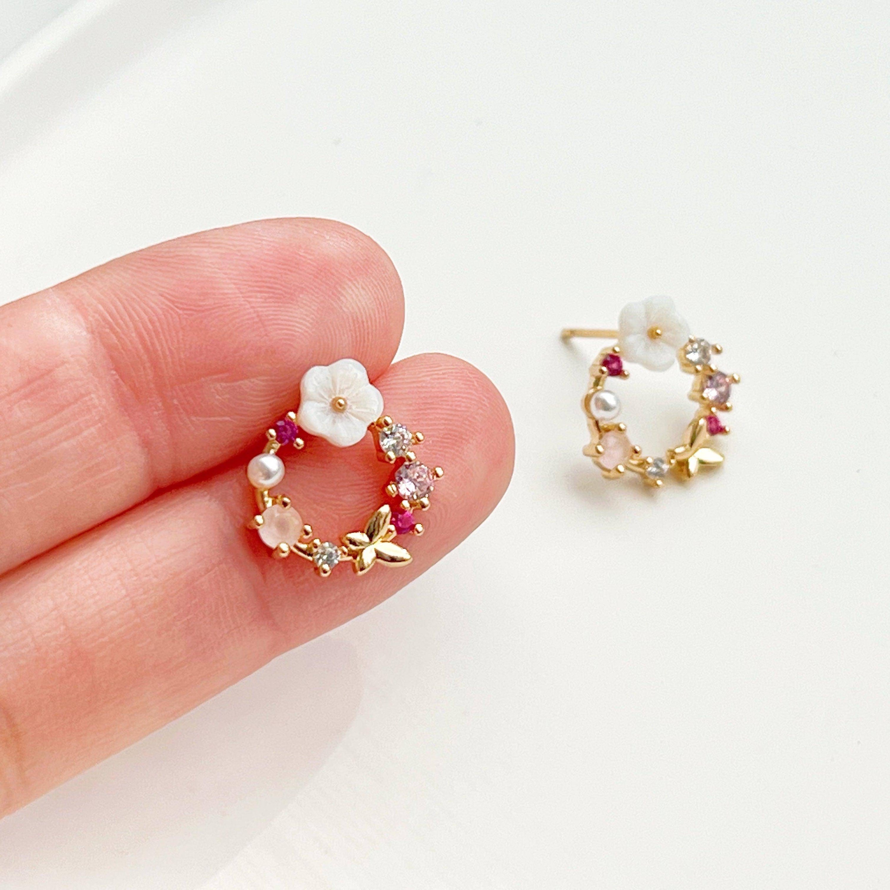 Elegant gold flower wreath earrings with pink crystals and pearls, showcasing a delicate floral design.