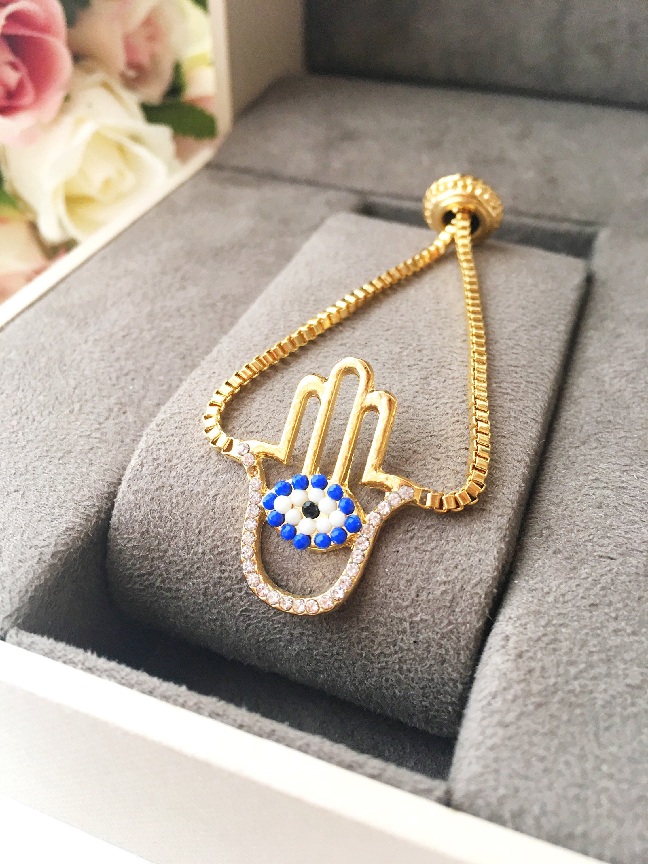 Gold Hamsa Evil Eye Bracelet featuring blue evil eye beads and adjustable stainless steel design.