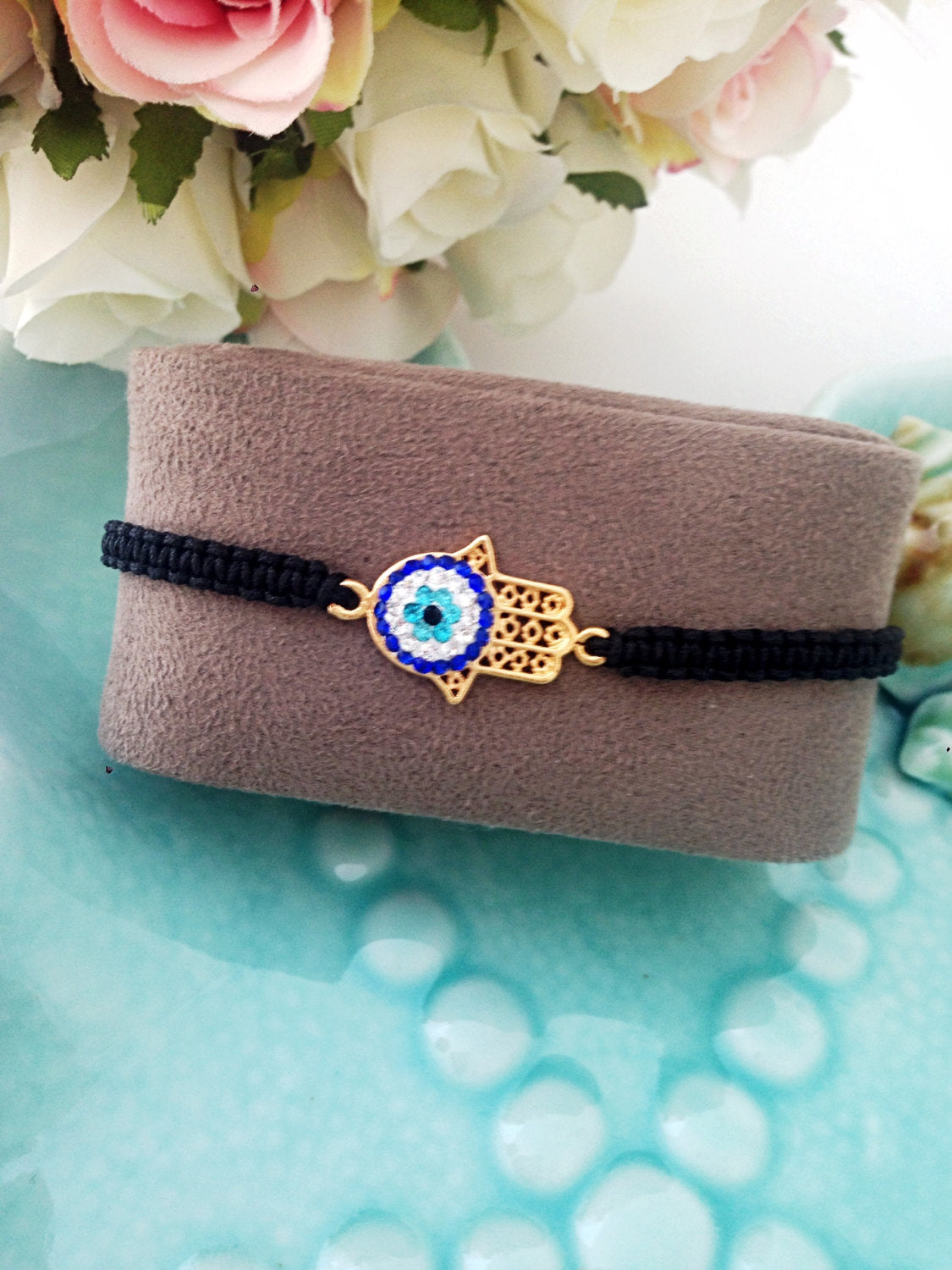 Gold Hamsa Evil Eye Bracelet featuring a silver-plated hamsa hand and evil eye charm on a black macrame band.