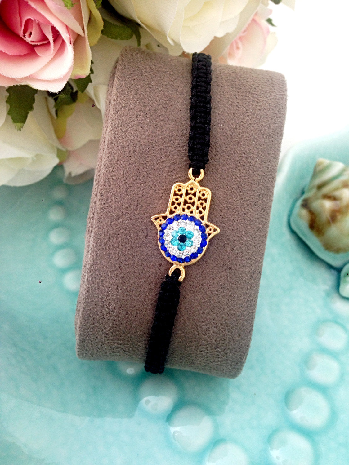 Gold Hamsa Evil Eye Bracelet featuring a silver-plated hamsa hand and evil eye charm on a black macrame band.