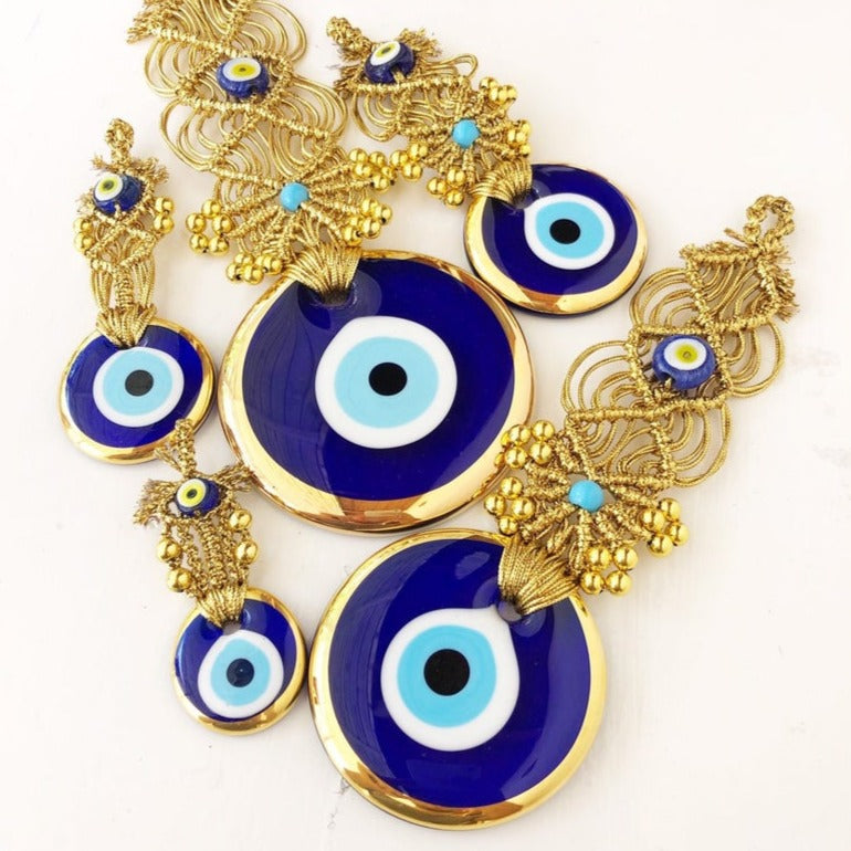 Gold macrame evil eye wall hanging featuring intricate designs and vibrant evil eye beads, symbolizing protection and good luck.